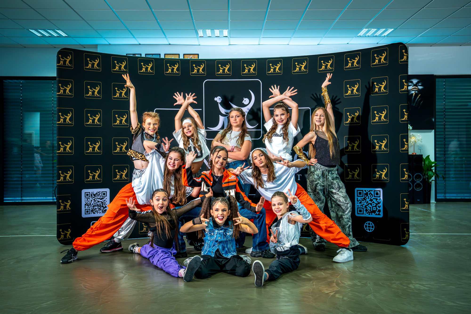 Große Born 2 Dance Tanzgruppe posiert ausgelassen vor der offiziellen Fotowand bei einem Tanz-Event